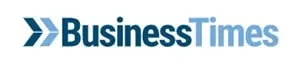 Logo with two blue arrows pointing right, followed by the words Business Times in a gradient from dark to light blue, on a white background.